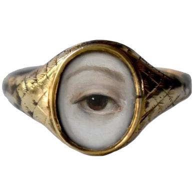 A bronzed ring; at the opus is a brown eye staring at you.
